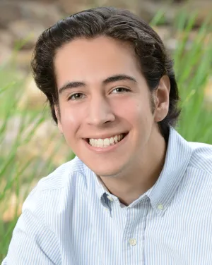 A man in a collared shirt smiling