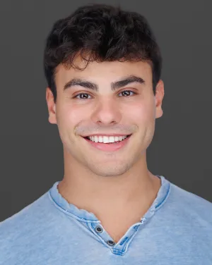 A man in a blue shirt smiles