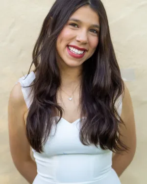 A woman in a white dress smiling