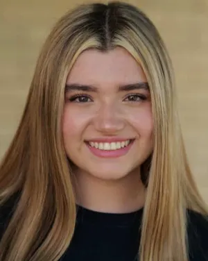 A woman with brown and blonde hair smiles