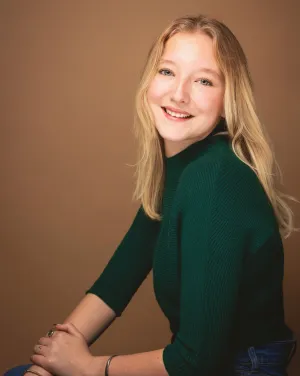 A woman with blonde hair in a green shirt smiles