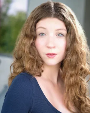 A woman with blonde curly hair wearing a blue shirt