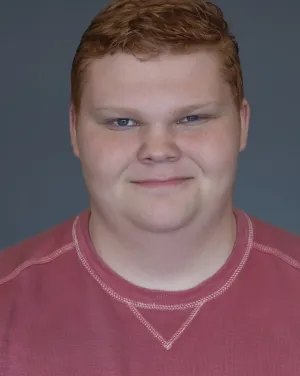 A man with ginger hair in a red shirt