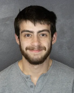 A man in a gray shirt smiling