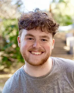 A man with short curly hair smiles