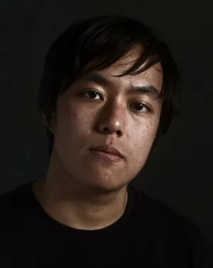 A man with black hair in a black shirt