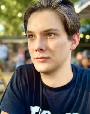 A man with short hair looks away from the camera