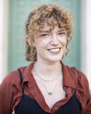 A woman with red curly hair smiles