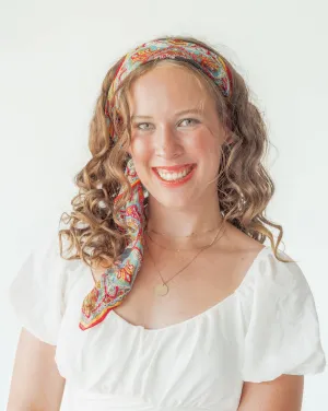 A woman with curly hair wearing a headband