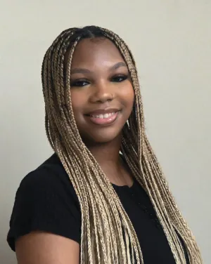 A woman with long blonde braids smiles