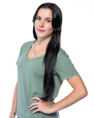 A woman with long black hair turns toward the camera