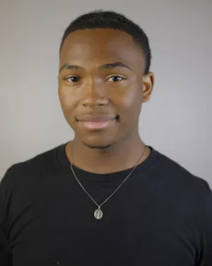 A person wearing a black shirt and necklace