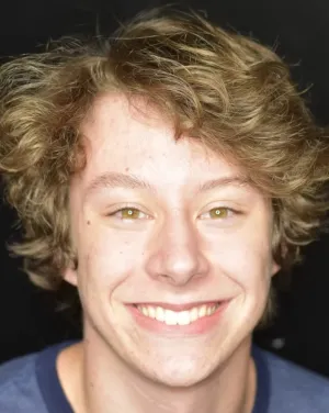 photo of a man with a blue t shirt and short light brown hair smiling
