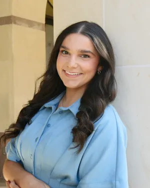A woman in a blue collared-shirt with long black hair