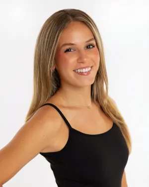 A woman in a black shirt turns and smiles