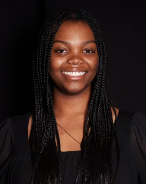 A woman with long black braids smiles