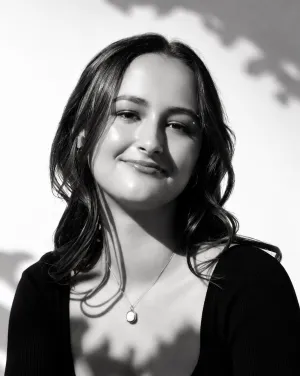 A black and white photograph of a woman with long hair smiling