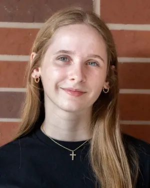 A woman with blonde hair in a black blouse smiles