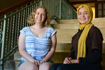 two women sitting on a bench smiling 