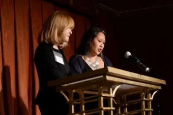 two women speaking at a podium