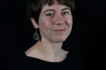 woman with short dark hair and blue eyes smiling