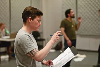 Man gives stage directions with pencil and arm tattoo 