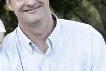 Smiling man in front of trees