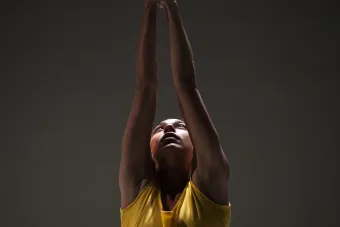 woman in yellow pointing upwards 