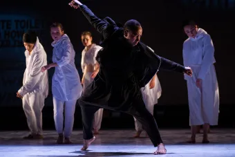 man dancing with ensemble in the background