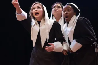 Three women pointing to something out of frame in The Crucible