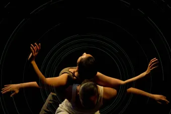 Two dancers, one lying on the back of another