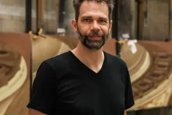 J.E. Johnson smiles in front of scenic backdrop paintings