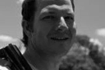 Smiling man in front of trees
