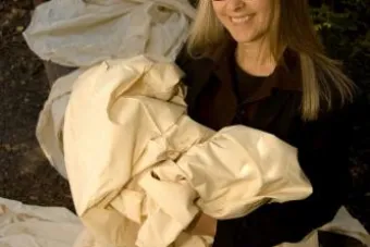 woman with grey hair holding pile of fabric 