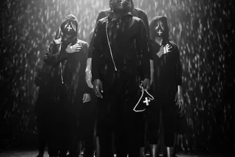 dancers wearing and holding masks with projections over them