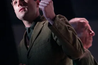 man holding hand up with spotlight on face