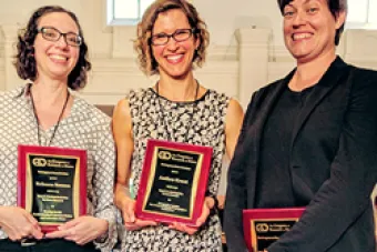 three women holding plaques