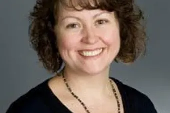 Woman with brown hair smiling at camera