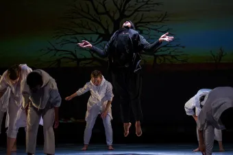 man in all black hovering above the floor 