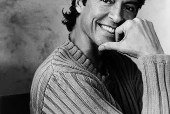 Man in black and white with face on hand