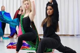 two female dancers with arms upraised