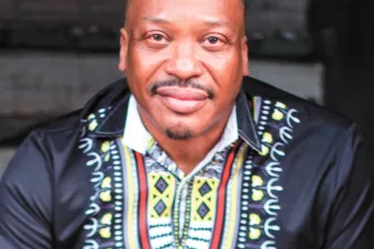 Man with goatee wearing a black shirt with red, yellow and white patterns
