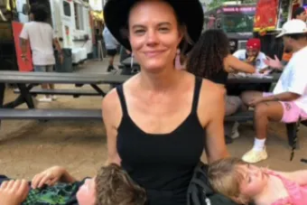 Christin Davis sitting with two children laying down on either side of her