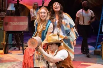 Three stage actors posed in a yelling or singing position