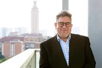 A headshot of Dean Ramón Rivera-Servera standing with the UT tower in the background