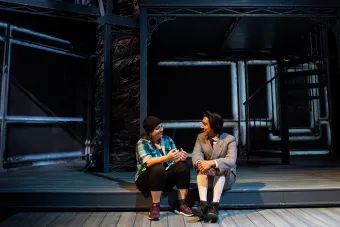 A graduate director sits on the set for SPRING AWAKENING and talks to an actor