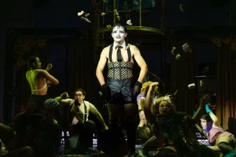A man in white face paint taunts the audience