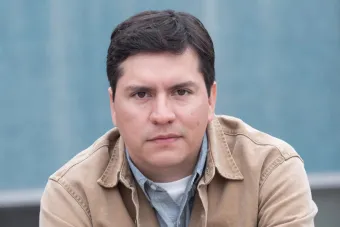 Headshot of a man with short brown hair and a tan work jacket