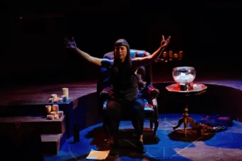 A woman closes her eyes and extends her arms into the air