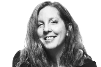A black and white headshot of a woman smiling